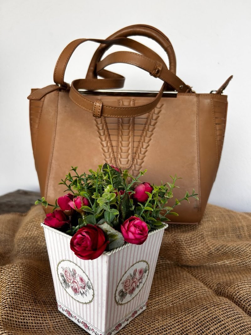 Bolsa Schütz em couro caramelo tamanho M, com alças de mão e detalhe trançado na frente